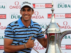 Rafael Cabrera-Bello holds the trophy after winning the Dubai Desert Classic at the Emirates Golf Club in Dubai, United Arab Emirates, Feb. 12, 2012. (ASHMED JADALLAH/Reuters)