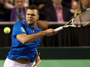 Jo-Wilfried Tsonga returns a shot to Frank Dancevic during their Davis Cup match in Vancouver, B.C., Feb. 12, 2012. (BEN NELMS/Reuters)