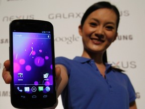A model poses with the Galaxy Nexus, the first smartphone to feature Android 4.0 Ice Cream Sandwich and a HD Super AMOLED display, during a news conference in Hong Kong Oct. 19, 2011.  REUTERS/Bobby Yip