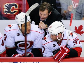 Hurricanes head coach Kirk Muller gives instructions to forwards Anthony Stewart (left) and Tim Brent during a game against the Flames at the Scotiabank Saddledome in Calgary, Alta., Dec. 6, 2011. (TODD KOROL/Reuters)