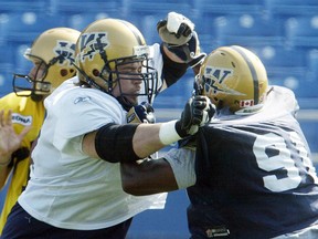 Bombers offensive lineman Steve Morley (left) tangles with defensive end Shawn Maynes during practice.