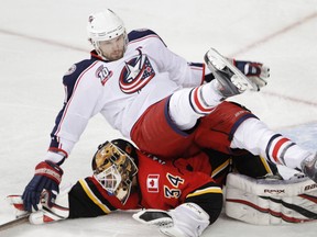 Blue Jackets forward Rick Nash falls over Flames goaltender Miikka Kiprusoff at the Scotiabank Saddledome in Calgary, Alta., March 4, 2011. (LYLE ASPINALL/QMI Agency)