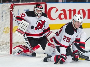 New Jersey Devils defenceman Mark Fayne (29) reacts as he blocks a New York Rangers shot in front of goalie Martin Brodeur (30) in the third period of their NHL hockey game at Madison Square Garden in New York, February 7, 2012. (REUTERS/Ray Stubblebine)