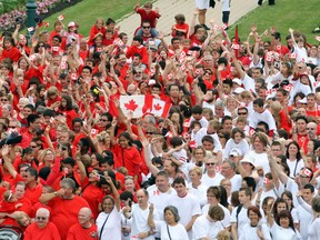 Winnipeggers wave flags while taking part in a living Canadian flag in front of the Manitoba Legislative Building in Winnipeg Friday July 01, 2011. (BRIAN DONOGH/QMI AGENCY)