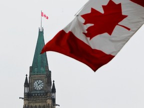 The Canadian flag is seen with the Peace Tower on Parliament Hill in Ottawa. . (ANDRE FORGET/QMI AGENCY)