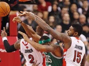 Raptors’ Amir Johnson and James Johnson go for a rebound against the Celtics’ Chris Wilcox during the first half NBA action at the Air Canada Centre last night. (REUTERS)