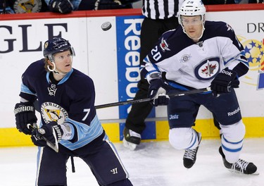 Pittsburgh Penguins Paul Martin (7) and Winnipeg Jets Antti Miettinen (20) keep their eyes on the puck in the first period of their NHL hockey game in Pittsburgh, Pennsylvania February 11, 2012. REUTERS/Jason Cohn (UNITED STATES - Tags: SPORT ICE HOCKEY)