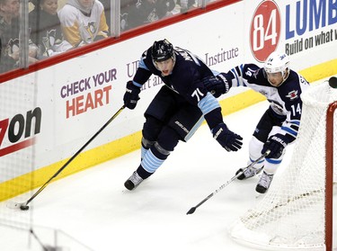 PITTSBURGH, PA - FEBRUARY 11: Evgeni Malkin #71 of the Pittsburgh Penguins handles the puck in front of Tim Stapleton #14 of the Winnipeg Jets during the game at Consol Energy Center on February 11, 2012 in Pittsburgh, Pennsylvania.   Justin K. Aller/Getty Images/AFP