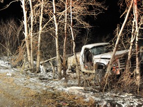 A pickup truck lies in trees off the road after a fatal crash near Stettler that killed a teenage female. (RCMP PHOTO)