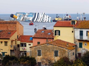 The oil tanker Elba (R) and the oil recovery sea platform Meloria (C) are seen near the capsized cruise liner Costa Concordia, which ran aground off the west coast of Italy, at Giglio island February 12, 2012. (REUTERS/Giampiero)
