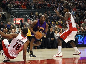 Lakers star Kobe Bryant drives between DeMar DeRozan (left) and Amir Johnson during the second half at the Air Canada Centre on Sunday. (Michael Peake/Toronto Sun)