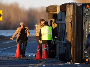 Investigators scour the scene of a passenger bus rollover near Redwater, Alberta February 10, 2012. As many as 31 people were injured in the incident, according to local media. Redwater is about 60 km (37 miles) north of Edmonton.  REUTERS/Dan Riedlhuber