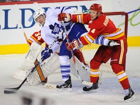 Flames defenceman Jay Bouwmeester (right) pushes  Maple Leafs forward Joffrey Lupul out from in front of goalie Miikka Kiprusoff on Tuesday night in Calgary. (Reuters)