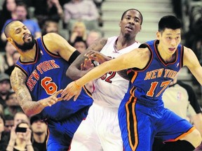 New York Knicks’ burgeoning young star Jeremy Lin (right) helps teammate Tyson Chandler guard Raptors forward Ed Davis last night at the ACC. Lin refers to his recent success as a “miracle.”