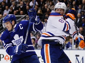 Toronto Maple Leafs Dion Phaneuf battles for the puck with Edmonton Oilers Sam Ganger (R) during the first period of their NHL hockey game in Toronto February 6, 2012.    REUTERS/Mark Blinch