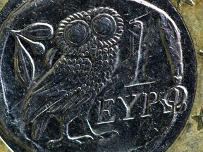 An owl, copied from an ancient Athenian 4 drachma coin, is seen on the face of a worn standard one-Euro coin issued in Greece in this illustration taken in Paris February 15, 2012. (REUTERS/Mal Langsdon)