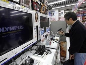 A man looks at Olympus Corp digital cameras at an electronics store in Tokyo February 13, 2012. (Reuters/Yuriko Nakao)
