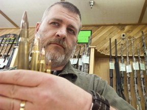 Gordon McGowan, president of MilArm Co., holds an assortment of ammunition, including the largest at .50 calibre, Wednesday at the company's store at 99 Street and 107 Avenue. (IAN KUCERAK/Edmonton Sun)