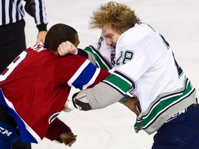 Oil Kings forward Klarc Wilson (left) fights Thunderbirds forward Jacob Doty at Rexall Place in Edmonton, Alta., Nov. 5, 2011. (CODIE McLACHLAN/QMI Agency)