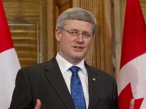 Prime Minister Stephen Harper held a photo opportunity to honour the National Flag of Canada on Flag Day in Ottawa on February 15, 2012. (CHRIS ROUSSAKIS/QMI Agency)