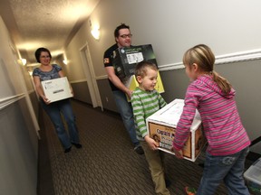The Peterson family, (left to right) Leslie Peterson, Joseph Peterson, Hunter Peterson, 6, and Caitlin Peterson, 7,  carry boxes out of their apartment as they begin the process of moving out of the Bellavera Green Condo Complex, 6201 Grant MacEwan Blvd., in Leduc Alberta , Saturday Feb. 25, 2012.  The 150 residents have been ordered to leave complex by March 31, due to worsening fire violations. An inspection at the 85-unit building back in December revealed numerous violations including a deficient fire alarm system, firewalls that had been damaged or removed, and an exterior staircase that had to be condemned. DAVID BLOOM EDMONTON SUN