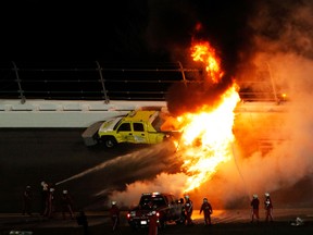 Safety workers try to extinguish a fire from a jet dryer after being hit by Juan Pablo Montoya.