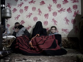 A picture taken on February 6, 2012 shows a Syrian family huddled under a blanket next to a heater in their house in the Baba Amr district of the central city of Homs during shelling by government forces. The Syrian army took full control on March 1, 2012 of the rebel neighbourhood which has been pounded for 27 straight days by artillery and tanks, a security official said.  AFP PHOTO/STR