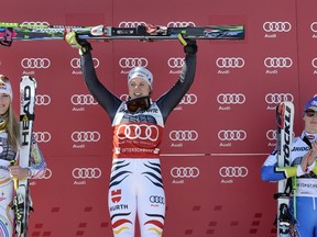 German winner Viktoria Rebensburg (C) is flanked by 2nd placed Linsey Vonn from the USA (L) and 3rd placed Tina Maze from Slovenia during the winners presentation after the FIS Alpine Ski World Cup women's giant slalom in Ofterschwang, southern Germany, on March 3, 2012.     AFP PHOTO/ THOMAS KIENZLE