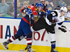 Keegan Lowe bangs the boards with the Swift Current Broncos’ Coda Gordon during the Oil Kings’ 2-1 win on Saturday. The Oil Kings were wearing special jerseys auctioned off for the Scouts who staged a sleepover at Rexall Place. (Edmonton Sun file)