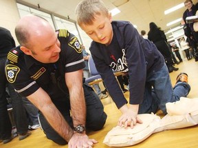 Rob Grimwood, Haldimand County's Manager of Emergency Services, shows 8-year-old Chase Park how to perform CPR during a CPR and Automated External Defibrillator Awareness Event held inside the Cayuga Memorial Arena;s community room on Wednesday Feb. 29, 2012. MATT DAY/THE CHRONICLE/QMI AGENCY