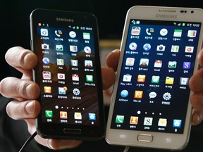 An employee poses with Samsung Electronics' Galaxy phones at a store in Seoul March 14, 2012. REUTERS/Kim Hong-Ji