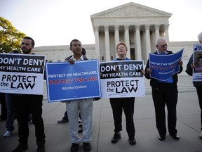 Healthcare law supporters rally on the sidewalk outside ongoing legal arguments over the Patient Protection and Affordable Care Act at the Supreme Court in Washington March 26, 2012. REUTERS/Jonathan Ernst