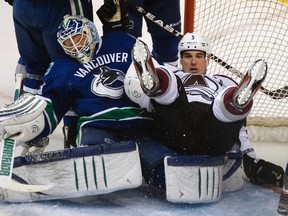 Avalanche defenceman Shane O'Brien falls on Canucks goaltender Cory Schneider at Rogers Arena in Vancouver, B.C., March 28, 2012. (ANDY CLARK/Reuters)