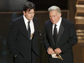 Charlie Sheen (L) and his father Martin Sheen present the best supporting actress in a miniseries or movie award during the 58th annual Primetime Emmy Awards at the Shrine Auditorium in Los Angeles Aug. 27, 2006.  REUTERS/Mike Blake