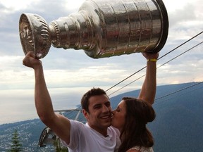 Boston Bruins Milan Lucic holds up the NHL Stanley Cup while getting a kiss from his girlfriend Brittany Carnegie atop Grouse Mountain in North Vancouver, British Columbia August 14, 2011. (REUTERS)