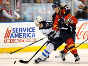 Winnipeg Jets' Jim Slater (L) and Florida Panthers' Kris Versteeg (R) fight for the puck during the first period of their NHL hockey game in Sunrise, Florida April 3, 2012.  REUTERS/Rhona Wise