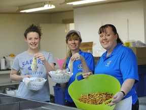 Alex Townsend, Cyndi Stymeist and Sarah Townsend all pitched in during last year's  Lynn Valley Lions Club Good Friday Perch Dinner at the Jr. Farmers Building in Simcoe. This year the Lynn Valley Lions will once again team up with the South Brant Lions Club for the annual fish fry. (Reformer file photo)