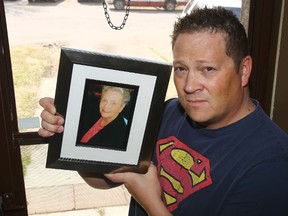 Mike Desjarlais holds up a picture of his mom, Dianna who passed away recently, at his front door of his home where his car containing his mother's ashes was stolen. DARREN MAKOWICHUK/QMI Agency