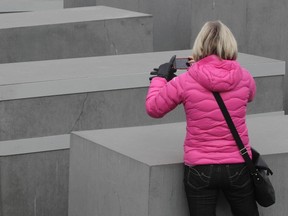 A woman takes a picture of a concrete pillar which has a steel collar attached, at the Holocaust memorial in Berlin March 15, 2012. (REUTERS/Tobias Schwarz)