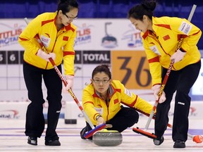 China's skip Wang Bingyu (C) watches the line of her shot as lead Zhou Yan (L) and second Yue Qingshuang play during their play-off match against Sweden at the World Women's Curling Championships in Esbjerg March 25, 2011. (REUTERS/Bob Strong)