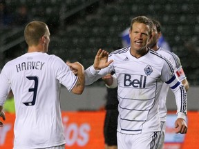 Jay DeMerit, of the Vancouver Whitecaps, celebrates with teammate Jordan Harvey after the Whitecaps defeated Chivas USA 1-0 in their MLS match at The Home Depot Centre on March 17, 2012 in Carson, California. (Victor Decolongon/Getty Images/AFP)