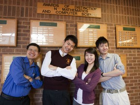 Norman Bethune math teacher Henry Tam (left) and students Roy Zhao, Jenfay Gan and Tony Wu stand in front of some of the school's many math awards. (MICHAEL PEAKE, Toronto Sun)