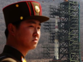 A soldier stands guard in front of the Unha-3 (Milky Way 3) rocket sitting on a launch pad at the West Sea Satellite Launch Site, during a guided media tour by North Korean authorities in the northwest of Pyongyang April 8, 2012. (Bobby Yip/REUTERS)