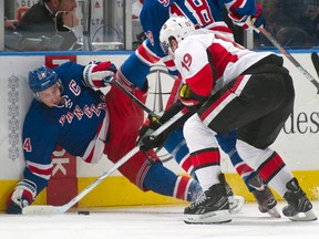 Rangers forward Ryan Callahan hits the boards as Senators forward Jason Spezza grabs the puck during Game 1 of their NHL Eastern Conference quarterfinal series at Madison Square Garden in New York, N.Y., April 12, 2012. (RAY STUBBLEBINE/Reuters)