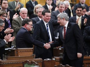 Prime Minister Stephen Harper shakes hands with Finance Minister Jim Flaherty after he delivered his budget in the House of Commons on Parliament Hill in Ottawa March 29, 2012.  (REUTERS/Chris Wattie)