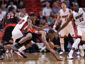 Miami Heat's Norris Cole (left) collides with Raptors' Ben Uzoh in
the first half of Toronto's 96-72 loss Wednesday night in Miami. (REUTERS)