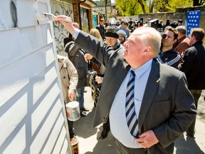 Mayor Rob Ford demonstrates painting  over graffiti for the media  in an alleyway  near St. Clair and Lansdowne in Toronto on Wednesday, April 18, 2012. (Ernest Doroszuk/Toronto Sun)