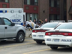 An injured man is taken away on a stretcher by paramedics from a Travelodge in Barrie on May 2, 2012. (CHERYL BROWNE/QMI Agency)