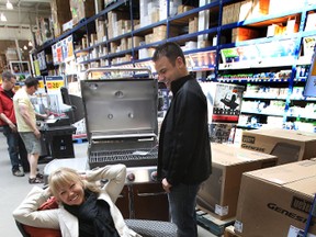 Andrea Brown tries out her new patio set while her husband Mitch checks out the new BBQ at the Edmonton Sun Oudoor Oasis Backyard Prize draw at the Southside Rona store in Edmonton, Alberta on Sunday, April 29, 2012.  Andrea was the lucky winner of the reverse draw.    PERRY MAH/EDMONTON SUN QMI AGENCY