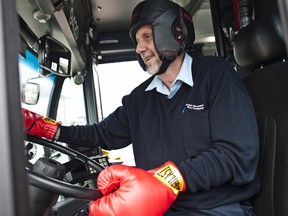 In hopes of illustrating the violence faced by transit operators, Charles Dixon, a bus driver who was assaulted last February returns to work Monday wearing boxing gloves and a sparring helmet in Burnaby, British Columbia, April 30. (CARMINE MARINELLI/QMI AGENCY)